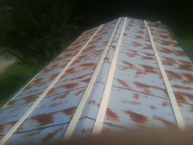 Rusted metal roof panels with new wood purlins before replacement — Storm Damage Roof Repair in New Carlisle by Roofing Brothers
